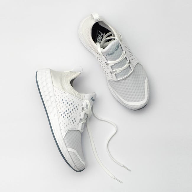White leather sneakers on gray background
